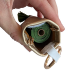 Interior view of a handmade poop bag holder, highlighting the durable stitching, velcro strip and roll of poop bags included.