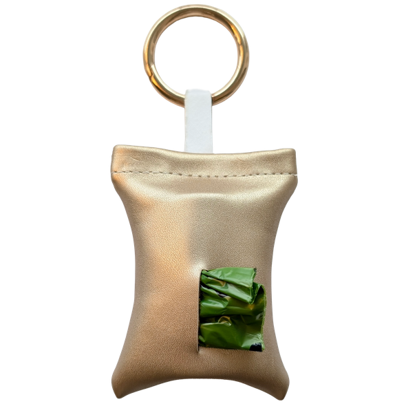 Gold color poop bag holder in vegan leather, handmade in Stockholm. The pouch features a metal ring and holds one roll of dog waste bags.